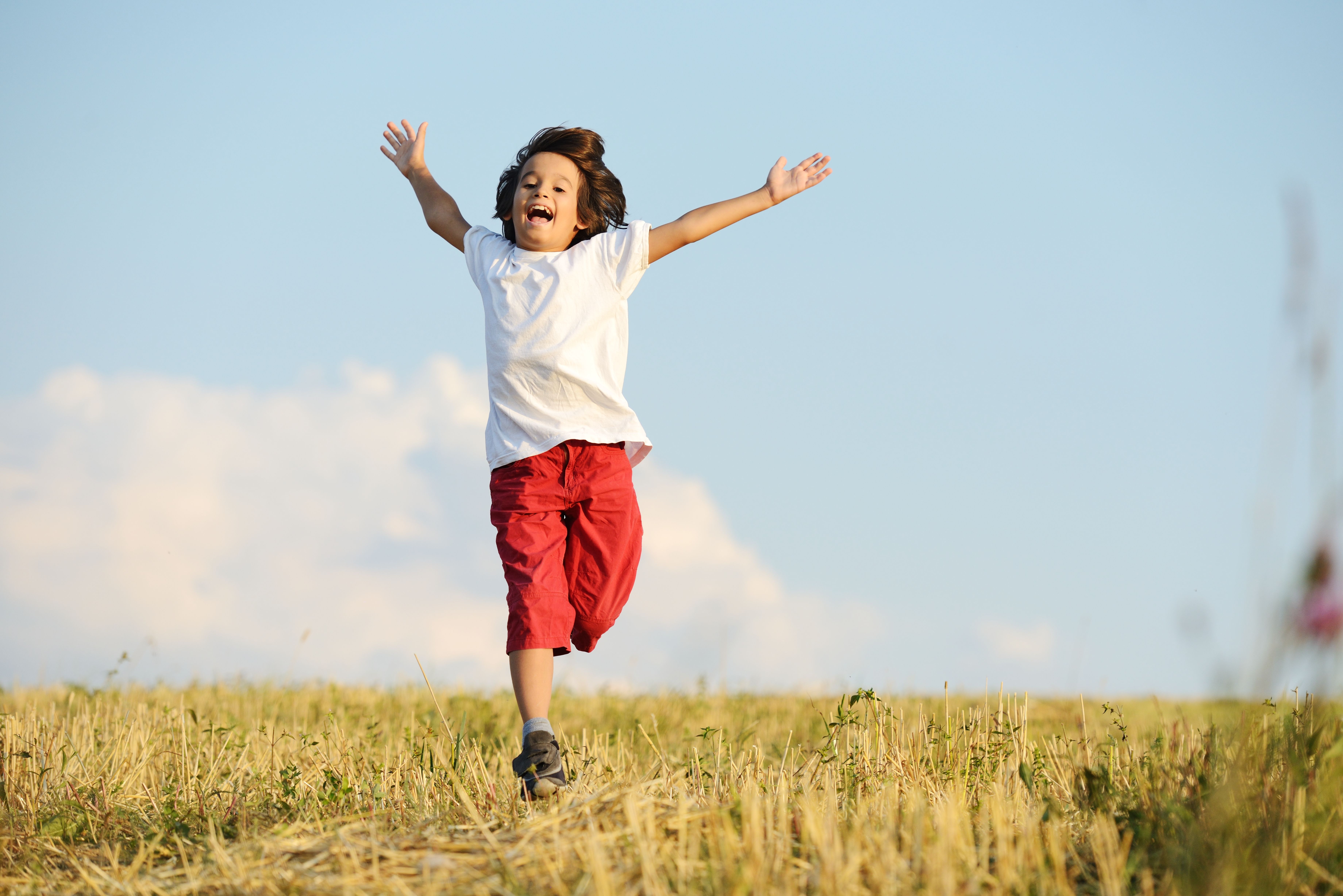 Happy child running on beautiful field